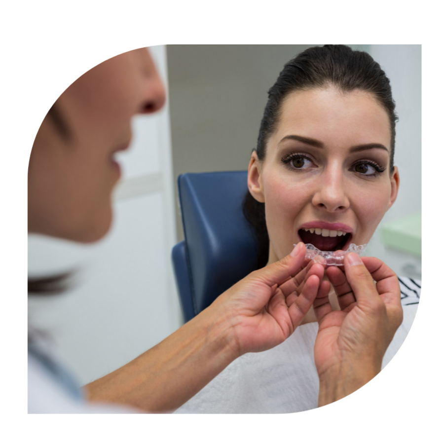 Dentist assisting a patient to wear invisible braces